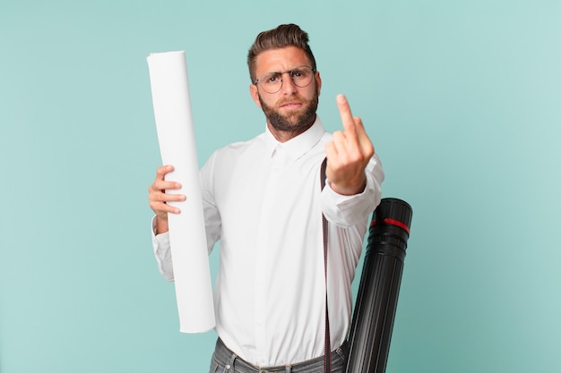 Jeune bel homme se sentant en colère, agacé, rebelle et agressif. concept d'architecte