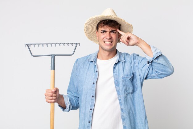 Jeune bel homme se sentant confus et perplexe, montrant que vous êtes fou. concept d'agriculteur