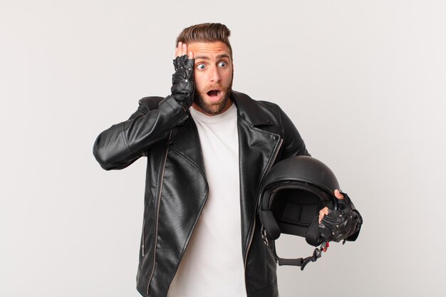 Jeune bel homme se sentant heureux, excité et surpris. concept de casque de moto