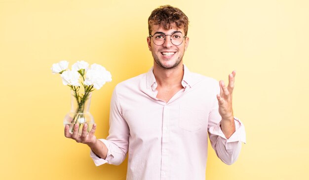 Jeune bel homme se sentant heureux, surpris de réaliser une solution ou une idée. concept de fleurs