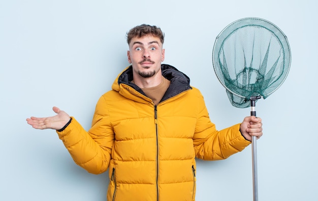 Jeune bel homme se sentant perplexe et confus et doutant. concept de pêcheur