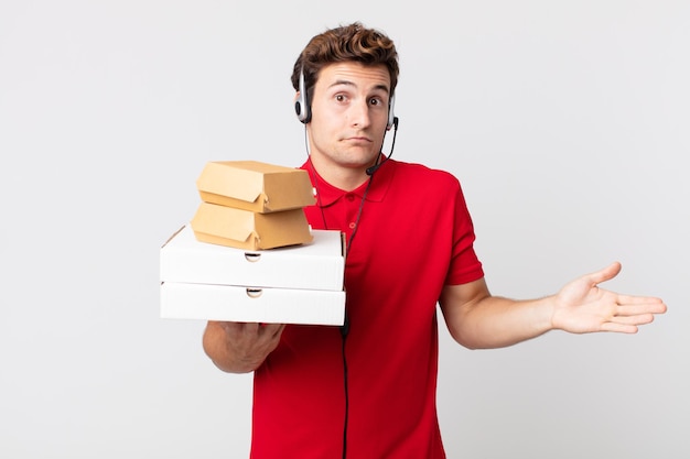 Jeune bel homme se sentant perplexe et confus et doutant. concept de restauration rapide à emporter