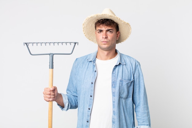 Jeune bel homme se sentant triste, contrarié ou en colère et regardant sur le côté. concept d'agriculteur