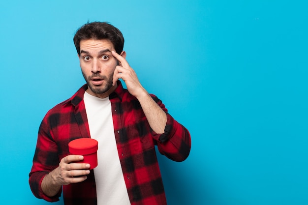 Jeune bel homme semblant surpris, bouche bée, choqué, réalisant une nouvelle pensée, idée ou concept