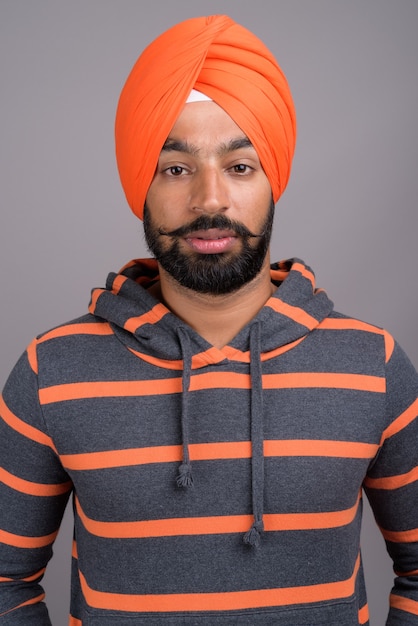 Jeune bel homme sikh indien portant turban orange