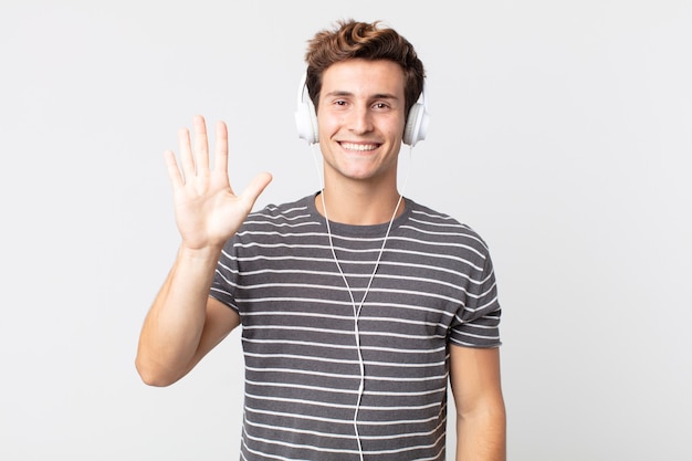 Jeune bel homme souriant et à l'air sympathique, montrant le numéro cinq. concept de musique d'écoute