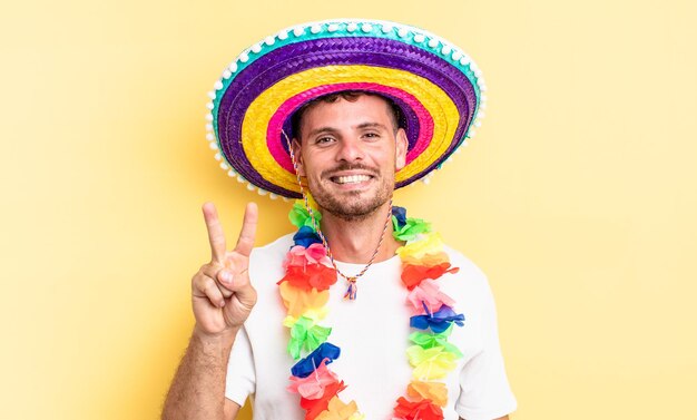 Jeune bel homme souriant et à l'air sympathique, montrant le numéro deux. concept de fête mexicaine