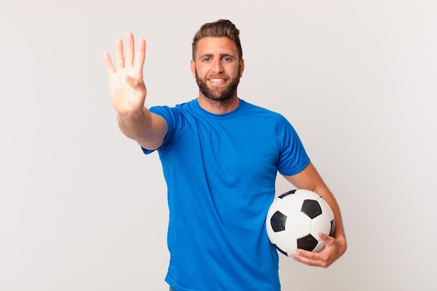 Jeune bel homme souriant et à l'air sympathique, montrant le numéro quatre. concept de football