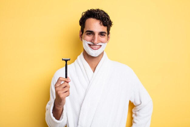 Jeune bel homme souriant joyeusement avec une main sur la hanche et confiant. concept de rasage et de mousse