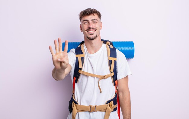 Jeune bel homme souriant et sympathique, montrant le numéro quatre. notion de randonneur