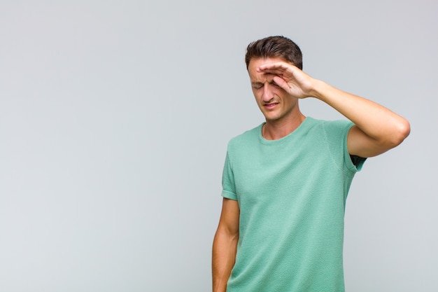 Jeune bel homme à la stressé, fatigué et frustré, séchant la sueur sur le front, se sentant désespéré et épuisé