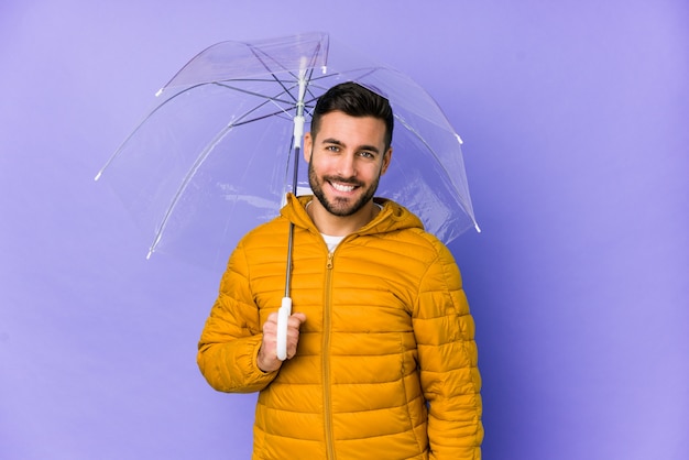 Photo jeune bel homme tenant un parapluie heureux, souriant et gai.