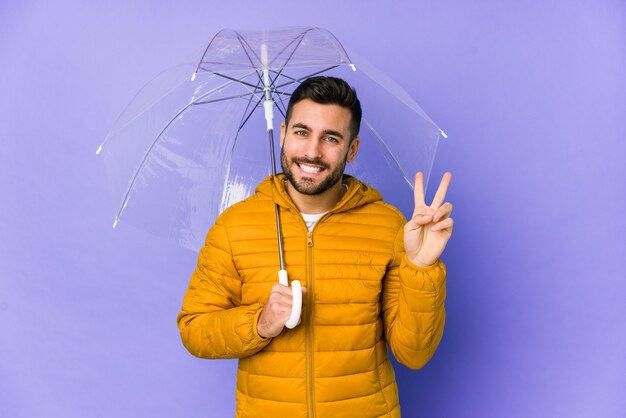 Jeune bel homme tenant un parapluie