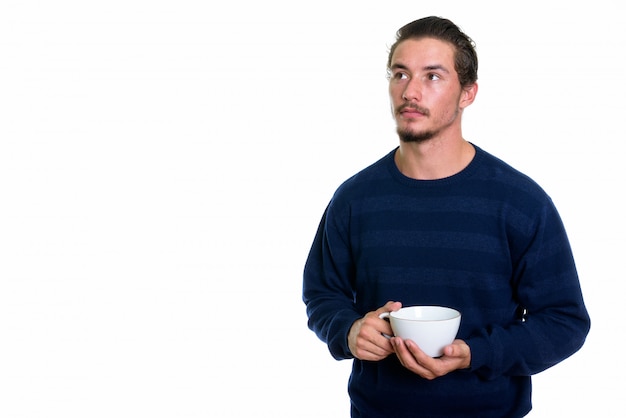 Jeune bel homme tenant une tasse de café