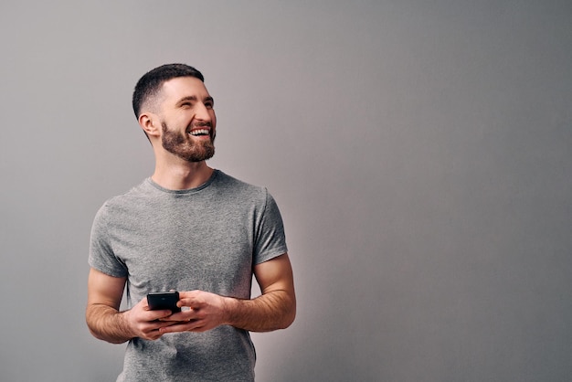 jeune bel homme vêtu d'un t-shirt gris se penche sur le côté et souriant Copy spaceAdvertising concept