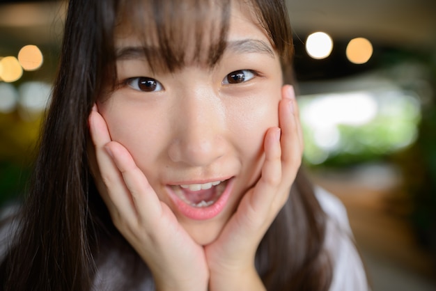 Jeune belle adolescente asiatique au jardin intérieur