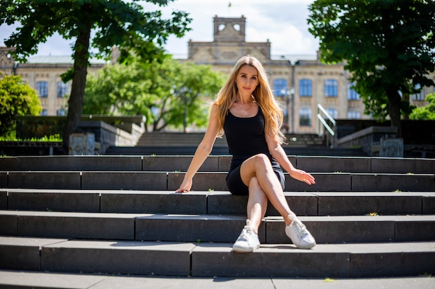 Jeune belle blonde femme sportive dans un débardeur noir et en noir serré