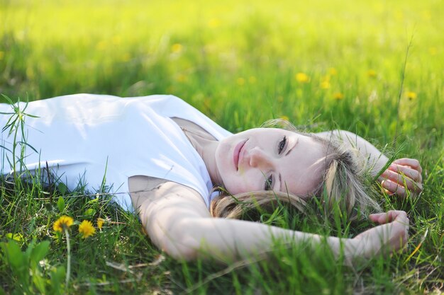 Jeune belle blonde se repose au printemps dans le parc.