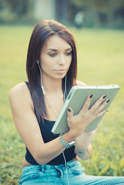 jeune belle brune cheveux raides femme à l&#39;aide de tablette et smartphone