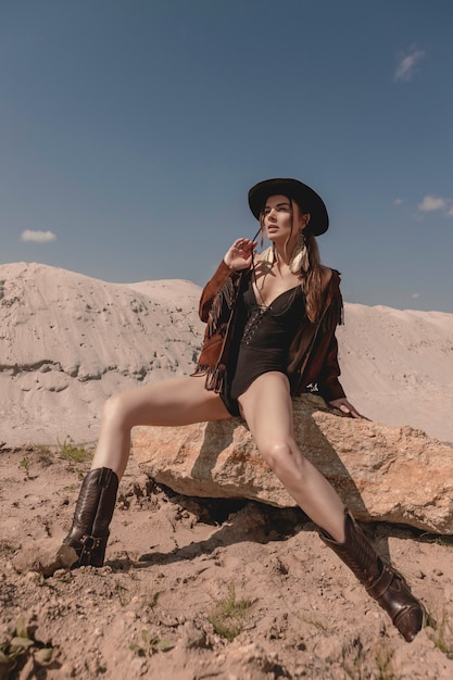 Jeune belle cowgirl posant dans le désert.