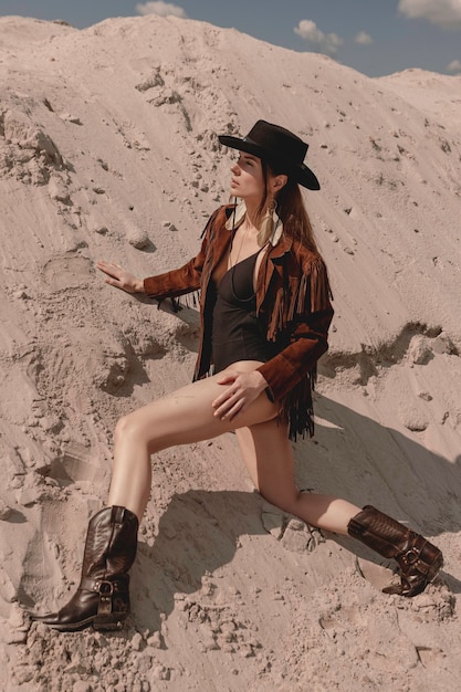 Jeune belle cowgirl posant dans le désert.