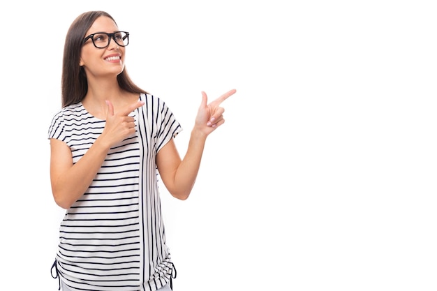 Jeune belle dame brune aux cheveux lisses vêtue d'un t-shirt rayé et de jeans la pointe