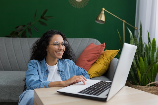 Jeune belle étudiante étudiant à distance en ligne à l'aide d'un ordinateur portable femme latino-américaine assise sur