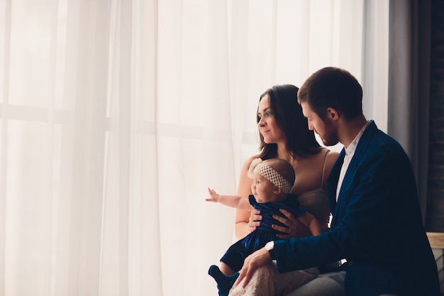 Jeune belle famille heureuse dans des vêtements élégants avec petit enfant souriant.