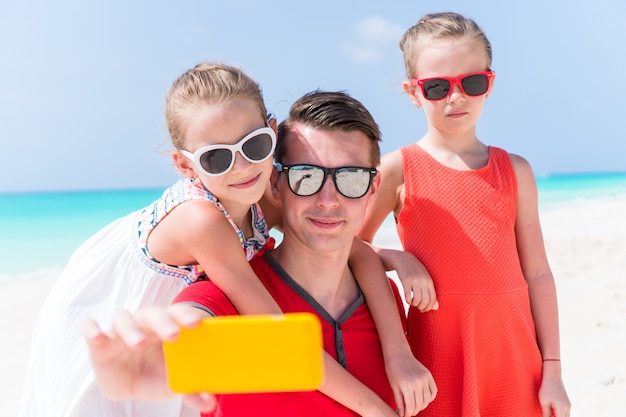 Jeune belle famille prenant un portrait de selfie sur la plage