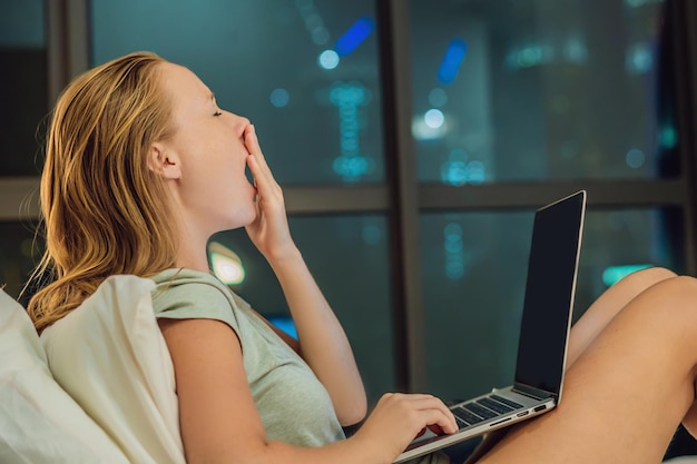 Jeune belle femme accro à Internet aux cheveux rouges caucasienne travaillant ennuyé sans sommeil et fatigué sur