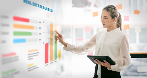 Jeune belle femme d'affaires à l'aide d'un écran de projection interactif analysant les informations de données commerciales