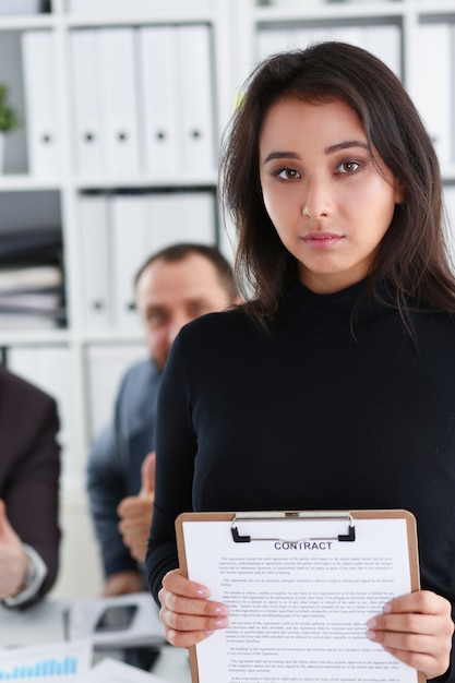 Jeune belle femme d'affaires brune tenir le classeur dans les mains