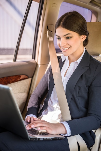 Jeune belle femme d'affaires réussie en voiture.