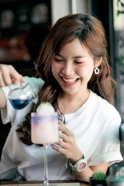 Jeune belle femme aime manger un dessert au café