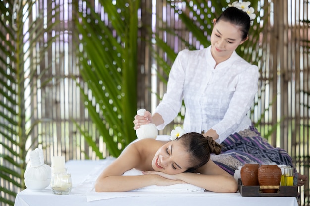 Jeune belle femme asiatique au spa, Massage thaïlandais naturel au spa, Femme asiatique sur lit de massage, détente et style de vie, Soins du corps, Corps du spa, Massage des mains, Femme se faisant masser dans le salon du spa.