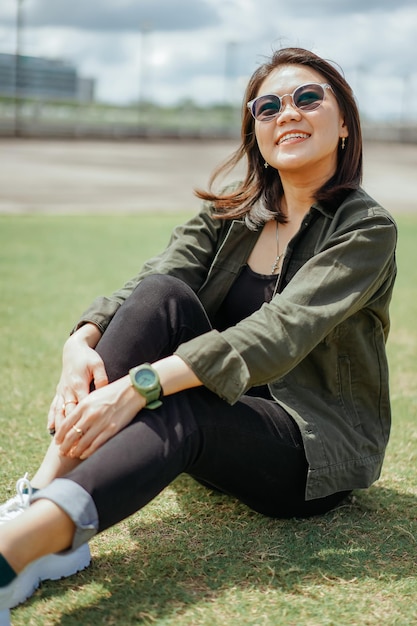 Jeune belle femme asiatique portant une veste et un jean noir posant à l'extérieur