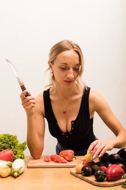 La jeune belle femme au foyer est occupée à préparer des aliments sains à la maison dans la cuisine