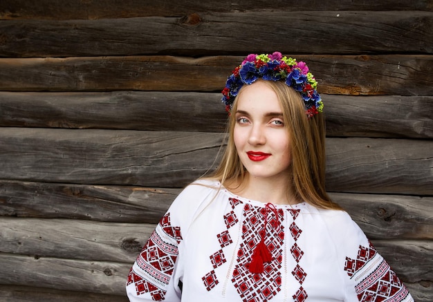 Jeune belle femme blonde aux cheveux longs en chemisier ukrainien et dans une couronne en plein air ethnique vi