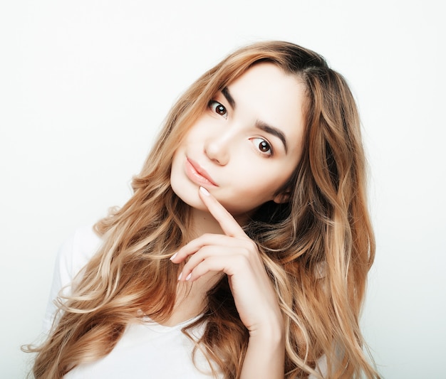 Jeune belle femme bouclée posant avec des t-shirts blancs, ower blanc