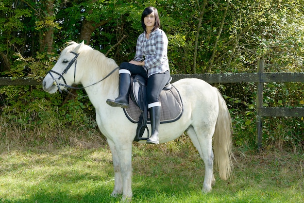 Jeune belle femme brune à cheval