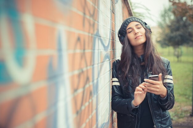 jeune belle femme brune écoute de la musique avec des écouteurs