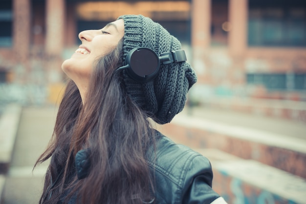 Photo jeune belle femme brune écoute de la musique avec des écouteurs