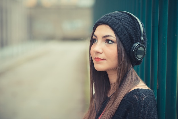 jeune belle femme brune fille écoutant des écouteurs de musique