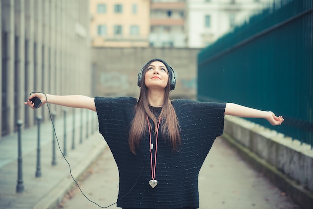 Photo jeune belle femme brune fille écoutant des écouteurs de musique