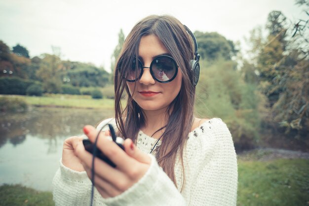 jeune belle femme brune fille écoutant des écouteurs de musique