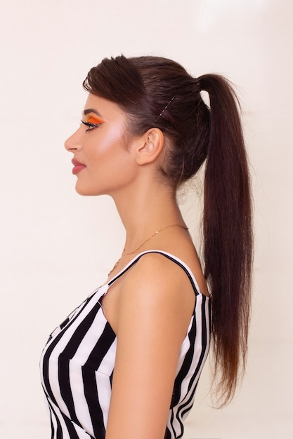 Jeune belle femme brune avec maquillage mode et coiffure