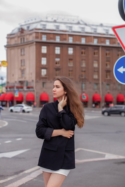 Jeune belle femme brune marchant dans la rue en centre-ville à l'heure du lever du soleil