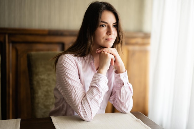 Jeune belle femme brune s'asseoir dans un café-restaurant café à l'intérieur