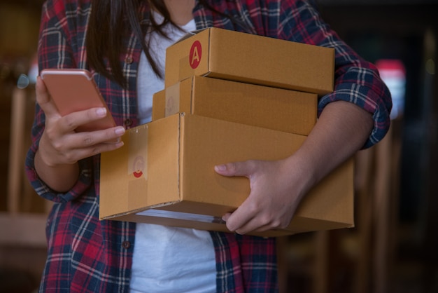 Jeune belle femme avec cale cadeau en mains