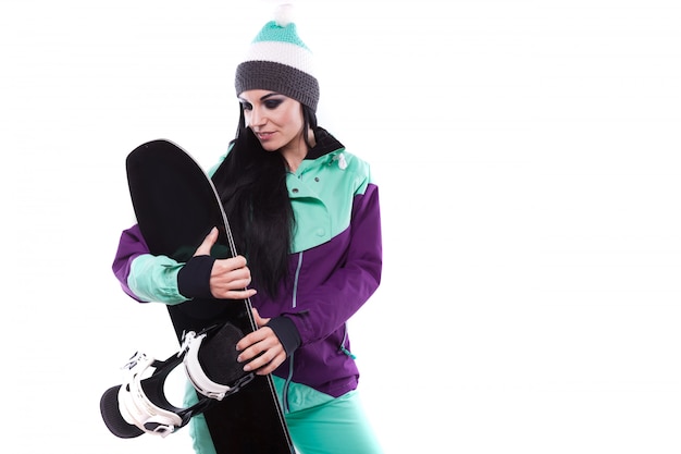 Jeune belle femme en costume de ski violet tenir snowboard